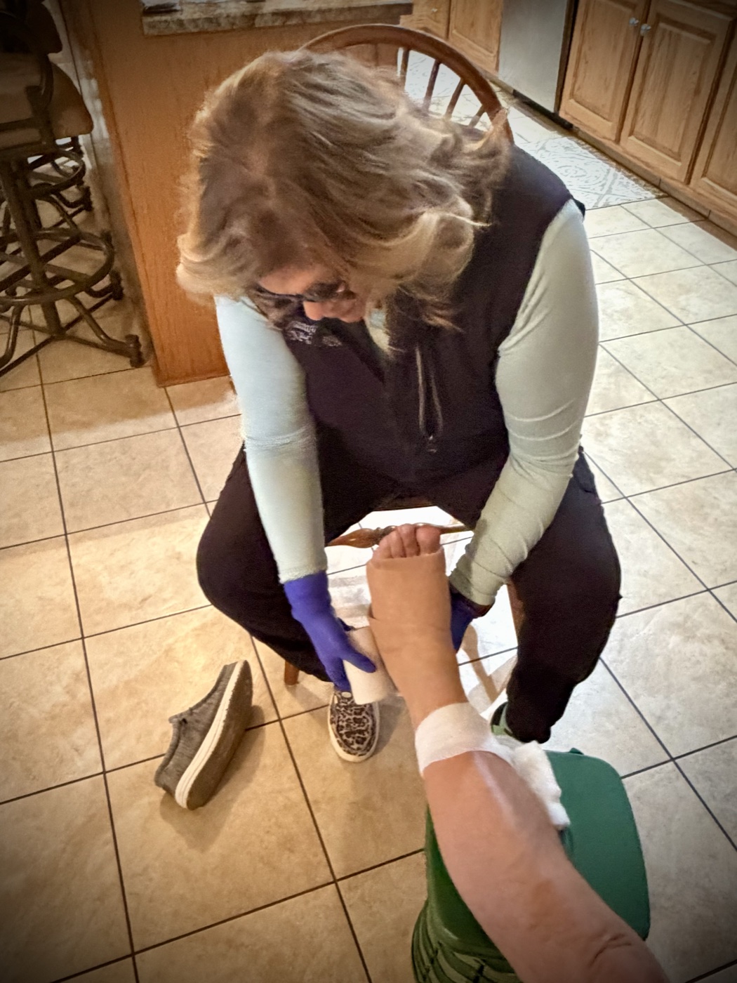 Certified nurse providing hands-on wound care in a patient's home
